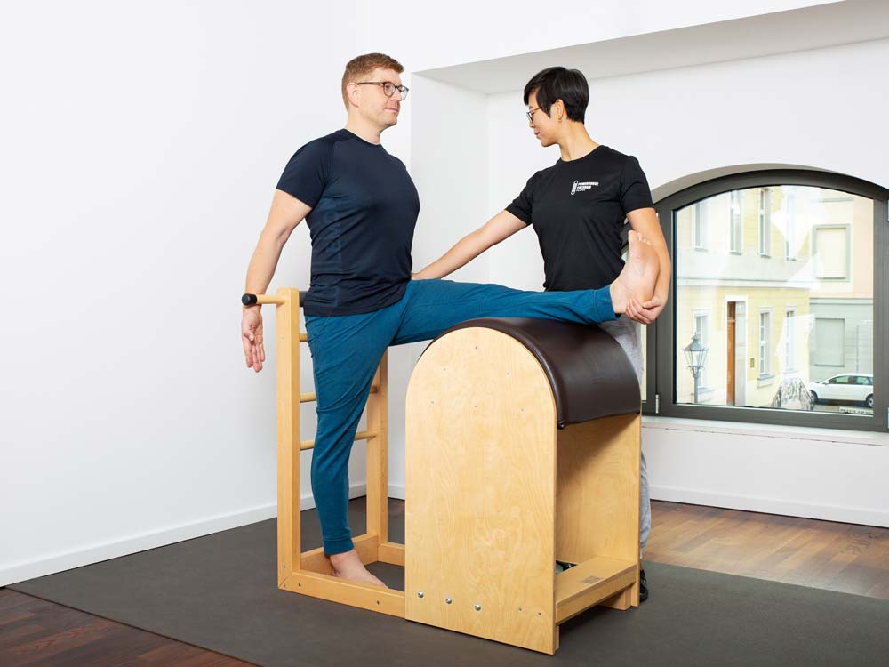 Das Foto zeigt die Trainer Angela Dorn und Christian Dorn gemeinsam während einer Übung an einem Pilatesgerät im Pilatesstudio 'Powerhouse Potsdam- klassisches Pilates an Geräten'.