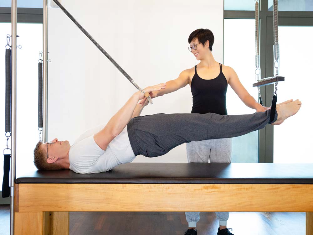 Das Foto zeigt die Pilatestrainer und Kursleiter Angela Dorn und Christian Dorn während einer gemeinsamen Übung im 'Powerhouse Potsdam', Ihrem Pilatesstudio für klassisches Pilates an Geräten.