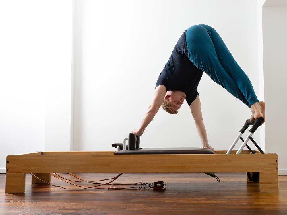 Das Foto zeigt Christian Dorn, den Pilatestrainer bei 'Powerhouse Potsdam', währen einer korrekt ausgeführten Übung an einem Pilatesgerät nach dem Originalvorbild von Joseph Pilates.